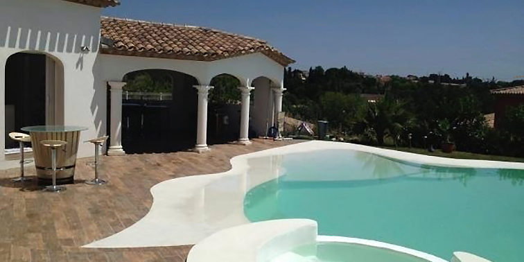 Bassin avec un spa en revêtement naturel beige piscine dans le 34 forme libre et beton armé revêtement couleur claire
