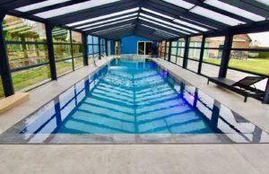 Piscine débordement miroir sous une magnifique véranda