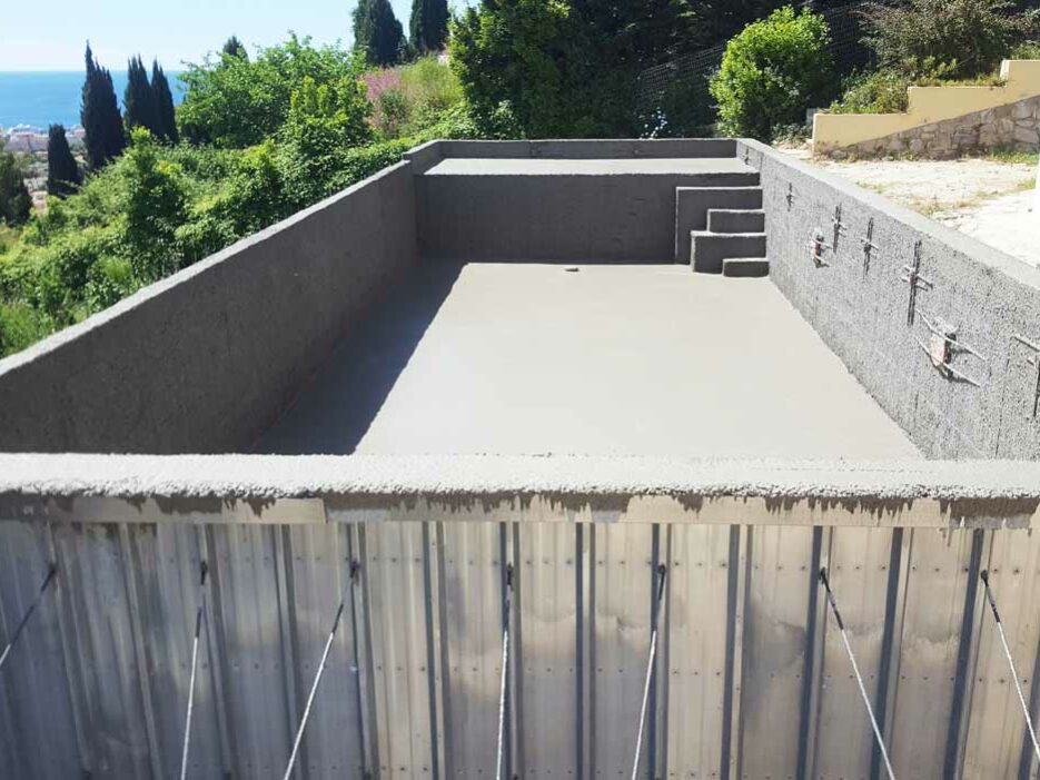 Piscine avec plage immergée et escalier en béton monobloc