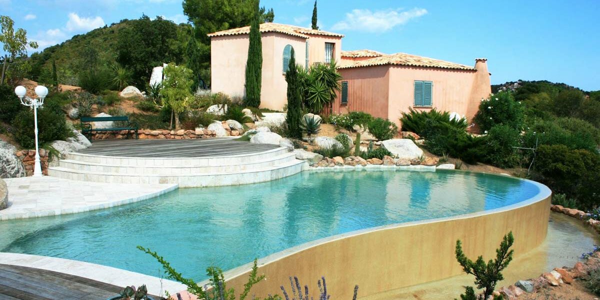 piscine forme paysagée pour cette magnifique réalisation de vert turquoise Construction traditionnelle pour ce bassin en béton