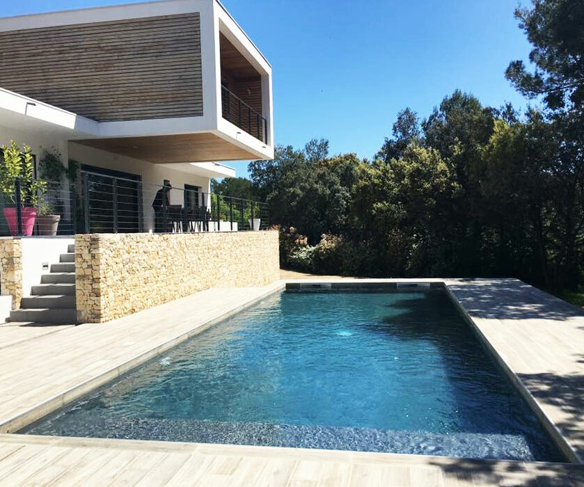 Une belle piscine contemporaine et design avec une maison type californienne