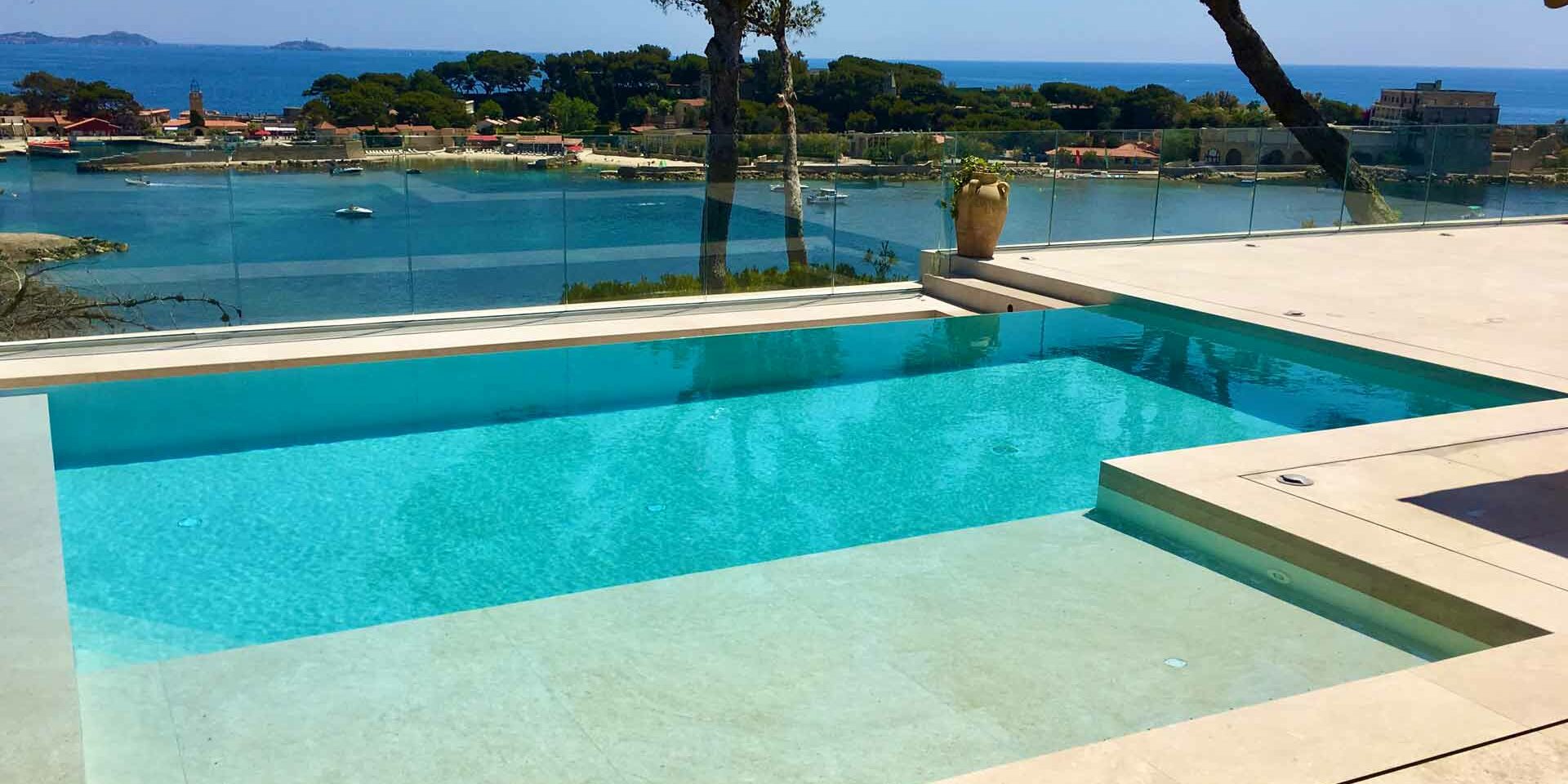 Piscine moderne contemporaine Superbe piscine béton à débordement carrelé en pierre et mosaïque réalisée par Jacques Hugony au Beausset 83